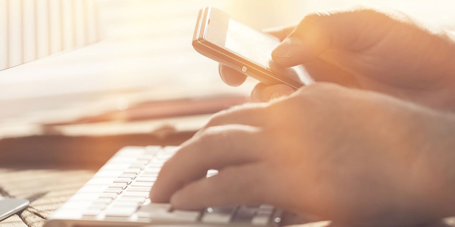 zajęte ręce z telefonem i klawiaturą